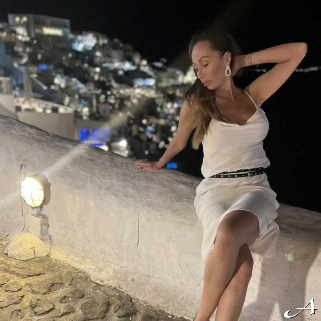 Doček Nove godine - žena sedi na zidiću